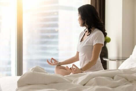 Kvinde mediterer på seng
