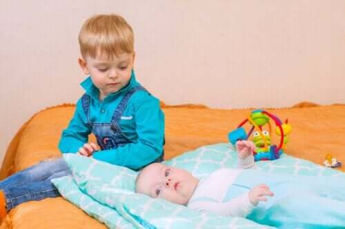 Lille dreng, der kigger på baby