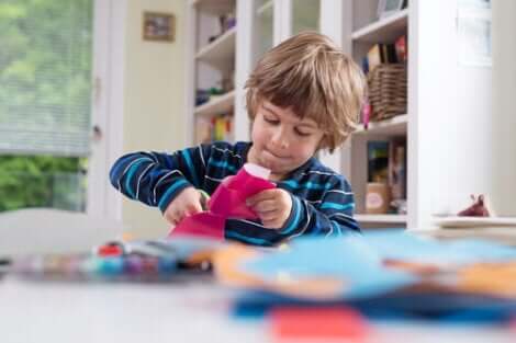 Lille dreng, der klipper i lyserødt papir