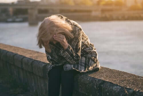 Stresset kvinde tager sig til hovedet grundet langtidsledighed