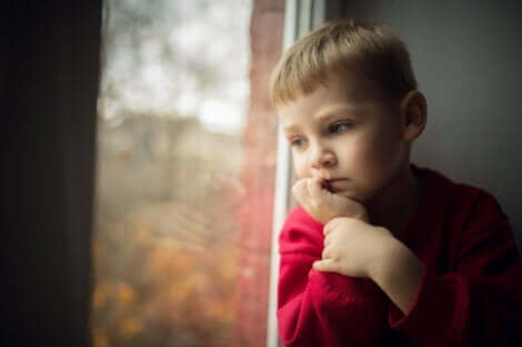 Lille dreng, der kigger ud af vindue