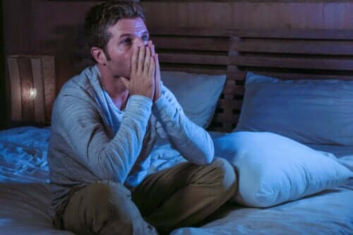 Mand, der sidder bekymret i seng