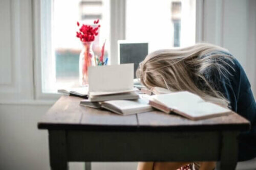 Kvinde, der sover hen over skrivebord