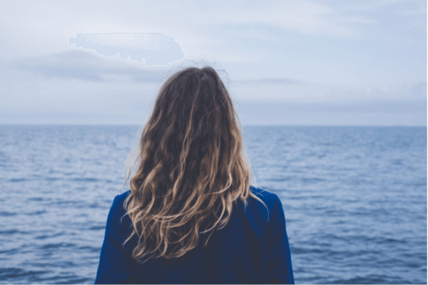 Kvinde, der ser ud over havet