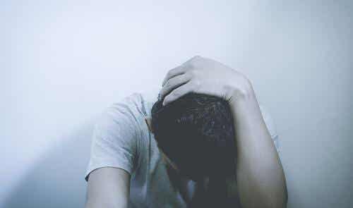 Mand sidder med hånden på hovedet