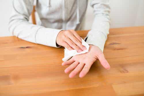 Person tørrer sin hånd med papir