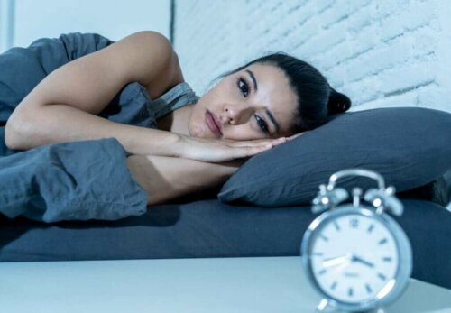 Kvinde ligger søvnløs i seng, selvom for lidt søvn skaber falske minder