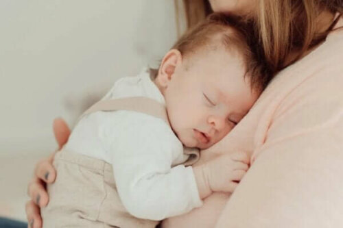 En baby sover hos sin mor