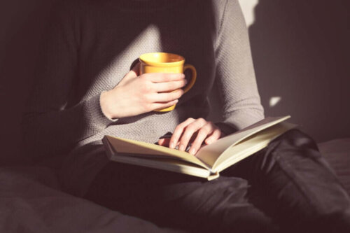 Person læser med te i hånden