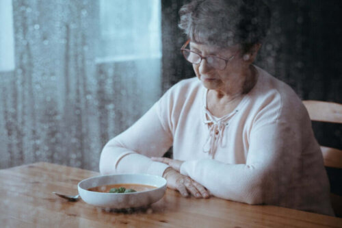 Ældre kvinde med suppe foran sig