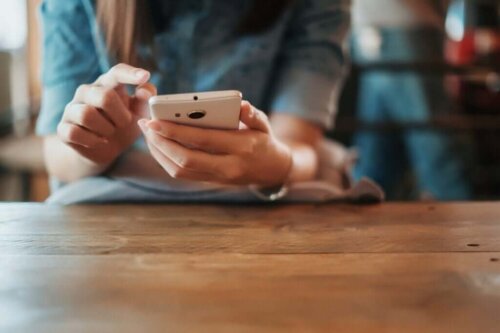 Kvinde sidder med telefon