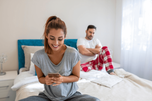 Frustreret mand i seng oplever, at partner kigger mere på sin telefon end på ham