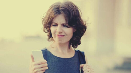Kvinde ser mistroisk på telefon, der viser deepfakes