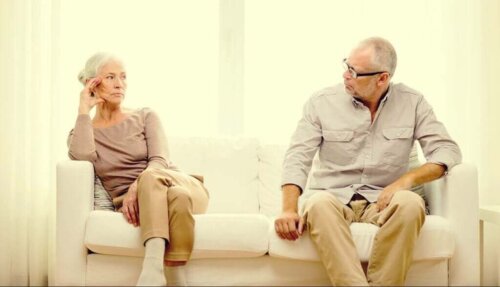 Ældre par sidder i sofa og ser på hinanden
