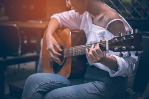Person spiller guitar, da det er aktiviteter til at afhjælpe stress