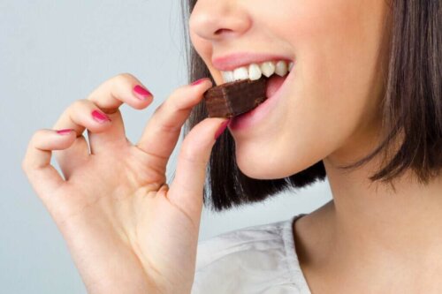 Kvinde spiser chokolade, selvom det er en af de mest vanedannende fødevarer