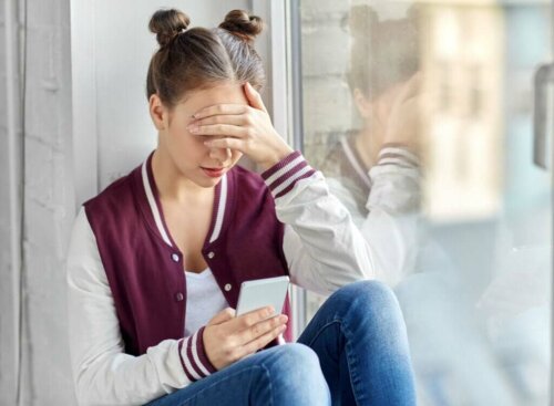 Pige med telefon ser på teenage-influencere