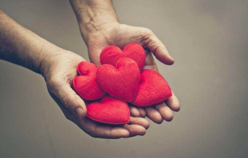 To hænder holder en masse hjerter som symbol for citat af Paulo Coelho om kærlighed
