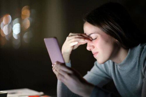 Kvinde med telefon oplever hovedpine og sammenhængen mellem natlys og depression