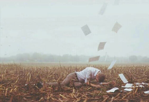 Mand på mark, hvor papirer flyver rundt, som symbol på at give slip på en eks