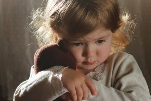 En lille pige krammer sin bamse