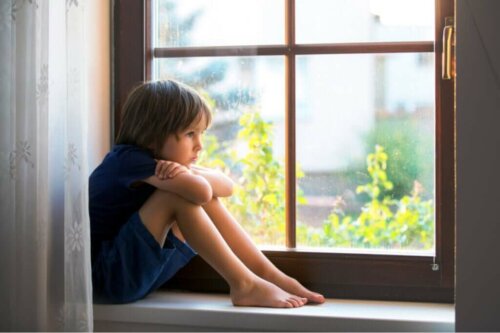 Barn sidder alene ved vindue
