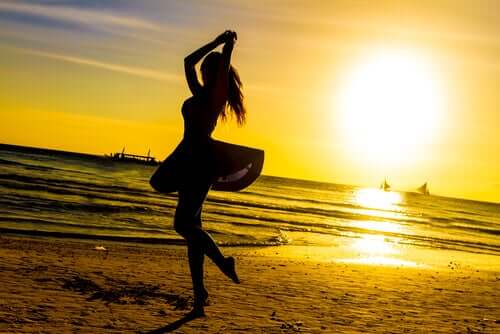 Fri kvinde danser på strand