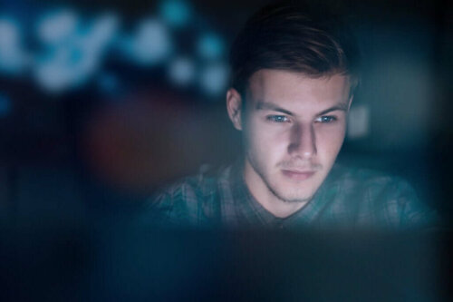 Mand sidder ved computer i mørke