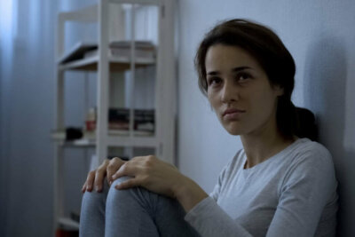 En skizofren kvinde sidder på gulv