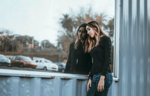 Trist kvinde læner sig op ad vindue