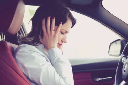 En angst kvinde i bil døjer med effekterne af pendling