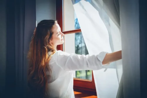 Kvinde åbner et vindue
