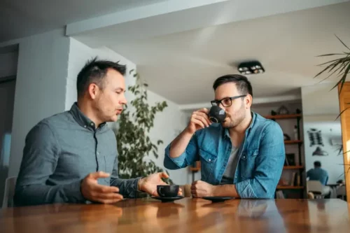 To mænd taler sammen over en kop kaffe