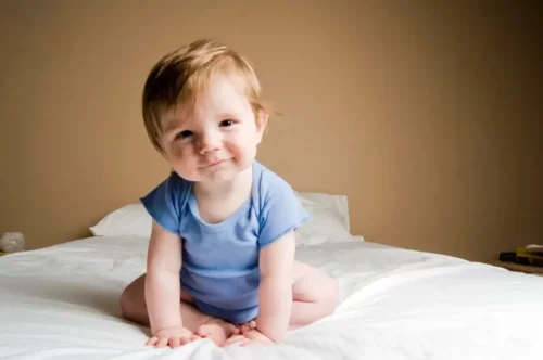 En smilende baby i en seng