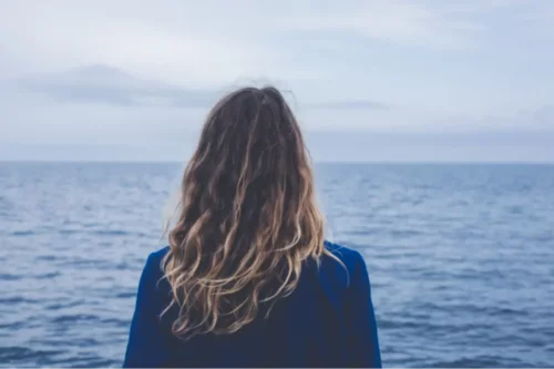 Kvinde står foran hav