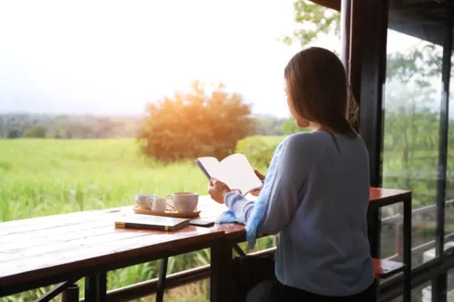 Kvinde læser med udsigt over grønne områder