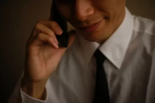 Mand, der taler i telefon og smiler, repræsenterer narcissistiske psykopater