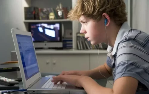 Dreng ser koncentreret på computerskærm