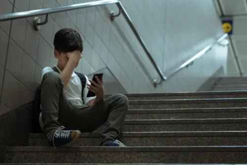 Dreng med telefon i hånden repræsenterer en årsag til angst i barndommen