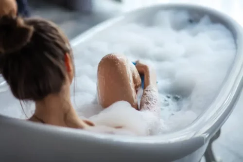 Kvinde nyder at bade i et badekar, da selvomsorg er en del af at arbejde med følelsesmæssig afhængighed