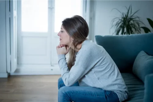 Kvinde på sofa græder og oplever, at livsbegivenheder kan ændre ens personlighed