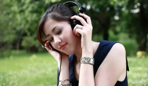 Kvinde nyder musik i høretelefoner