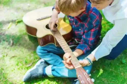 Barn er ved at lære at spille guitar som en del af unschooling