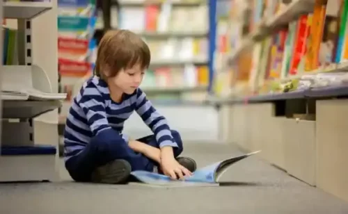 Dreng læser på gulvet