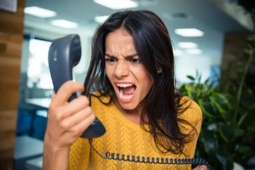 Kvinde råber af en telefon