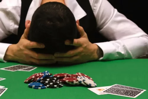 Mand er gamler og hviler hovedet på casinobord