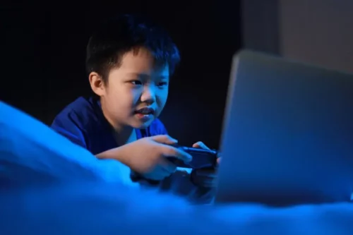 Dreng spiller videospil i mørke