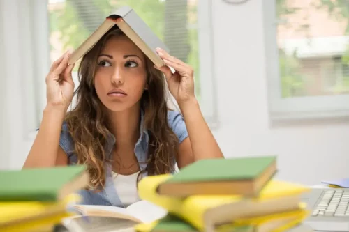Kvinde med bog på hovedet symboliserer, at du ikke kan koncentrere dig om at læse