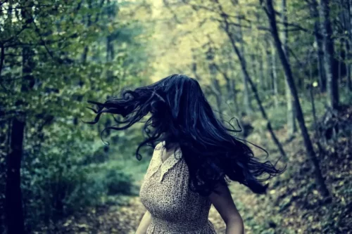 Bange kvinde løber i en skov