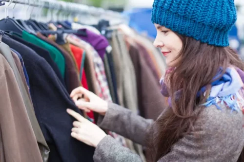 Smilende kvinde shopper forskelligt tøj